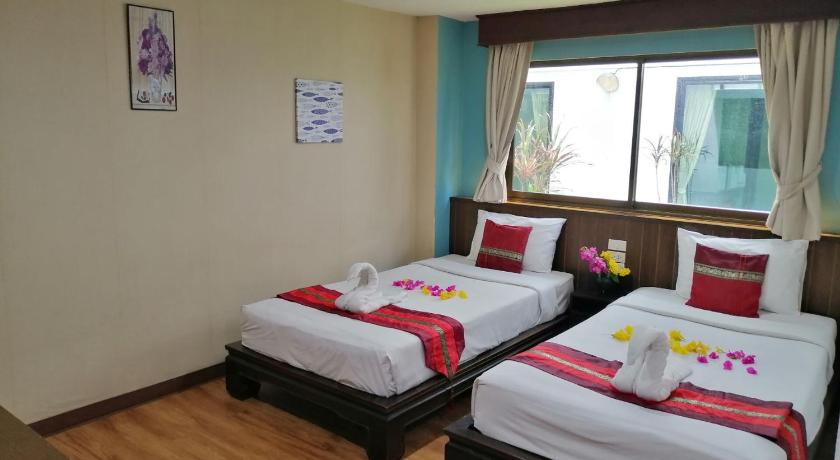 a hotel room with two beds and two windows, Mandala House in Chiang Mai