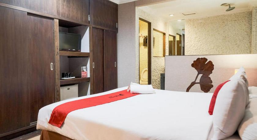 a hotel room with a bed, chair and a television, RedDoorz near WaterBoom Lippo Cikarang in Cikarang