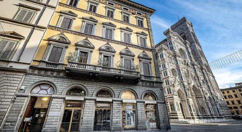 a large building with a clock on the front of it, Palazzo Gamba Apartments in Florence