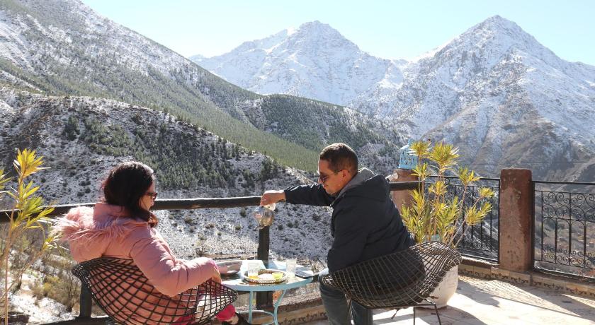 a man and woman sitting at a picnic table, Toubkal Garden in Tamatert