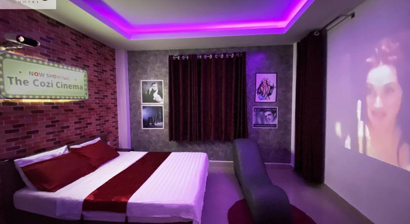 a hotel room with a bed and a television, Cozi 5 Service Apartment in Ho Chi Minh City