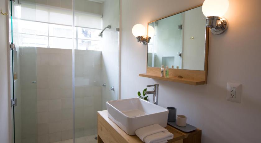 a bathroom with a sink, mirror, and bathtub, Casa Nuevo Leon in Mexico City