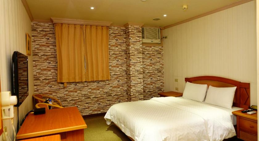 a hotel room with a bed, desk and a lamp, Lidu Hotel in Yilan
