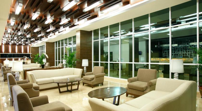 a living room filled with furniture and a large window, Hotel Santika Cikarang in Cikarang