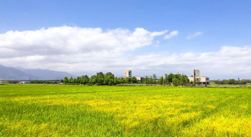 a grassy field with tall grass and trees, Villa LOHERB in Yilan