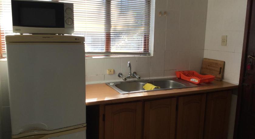 a kitchen with a sink, refrigerator, microwave and a window, Seaside Lodge B&B in Ballito