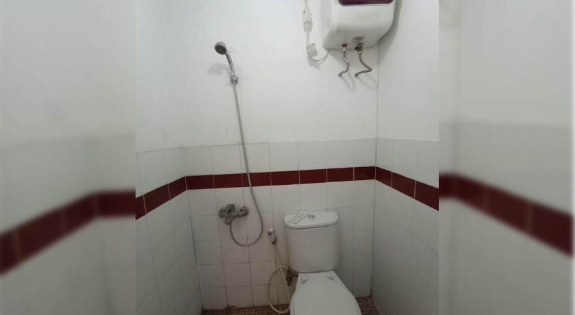 a white toilet sitting in a bathroom next to a wall, X-press bedroom Mutiara-Bekasi in Bekasi