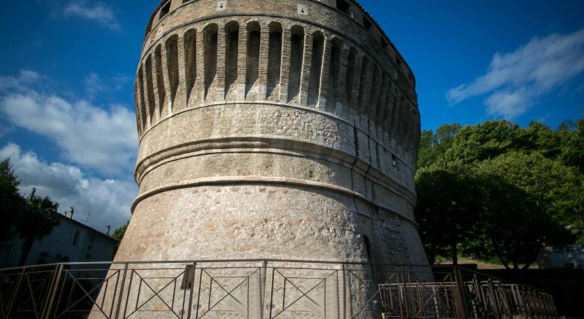 a large stone structure with a clock on top, Hotel Pineta in Cagli