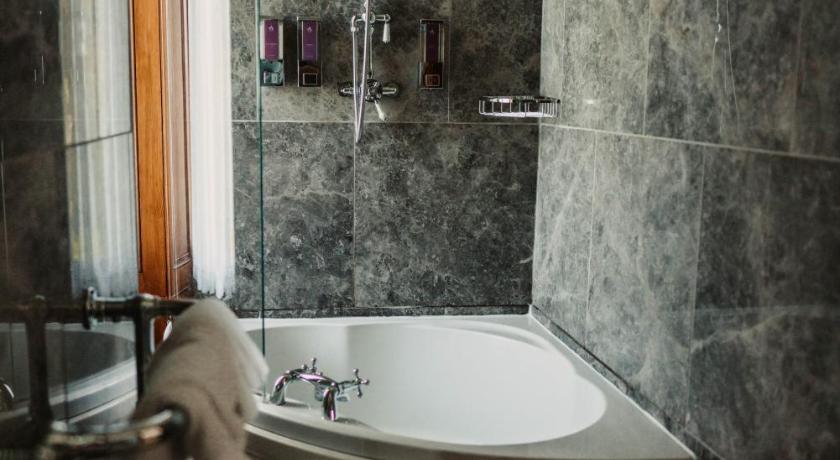 a bath tub sitting next to a toilet in a bathroom, Shieldaig Lodge Hotel in Gairloch