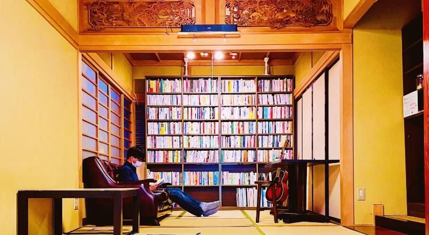 a person sitting in a chair in a room, 泊まれる図書館 寄処 -yosuga- in Toyama
