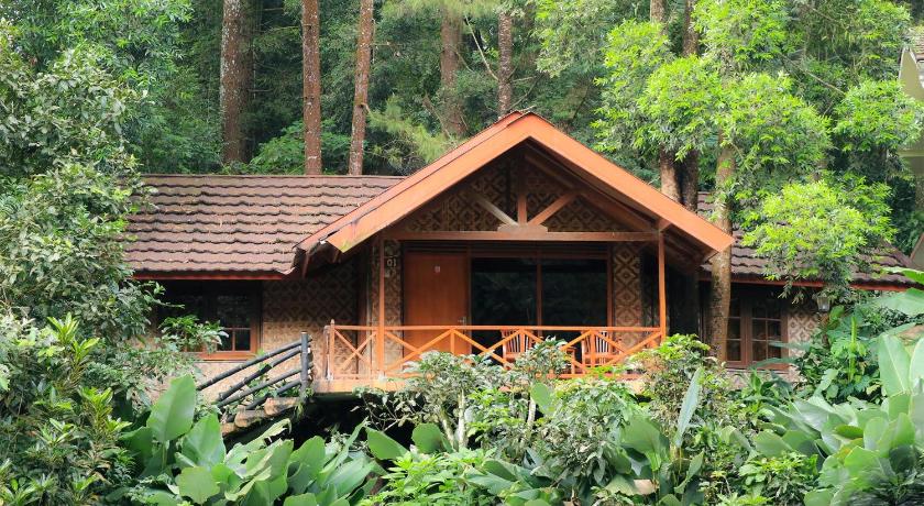 a large wooden house with trees and shrubbery, Safari Resort in Puncak