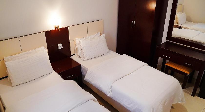 a hotel room with two beds and two lamps, Loaloat Al Khobar in Al-Khobar