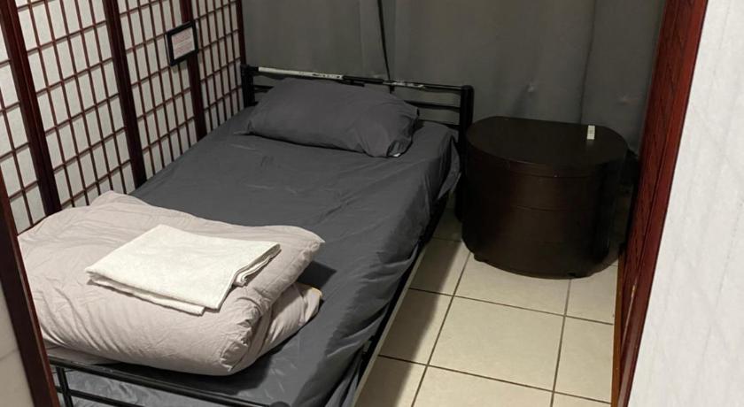 a bed in a room with a wall behind it, Private Cubicle - Single Bed - Mixed Shared Dorm - MIAMI AIRPORT in Miami (FL)