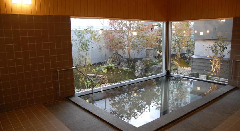 a bathroom with a glass door and a large window, Onsenryokan Marumo in Tottori