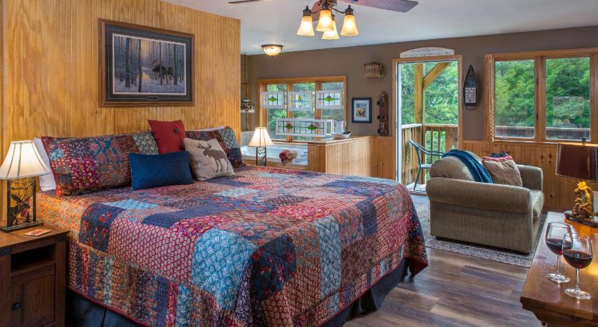 a bedroom with a bed, a chair, and a window, Eureka Sunset Cabins in Eureka Springs (AR)