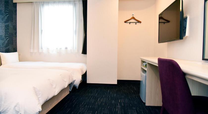 a hotel room with a bed and a desk, Miyazaki Daiichi Hotel in Miyazaki