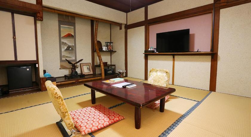 a living room filled with furniture and a tv, Hinode Ryokan in Ise