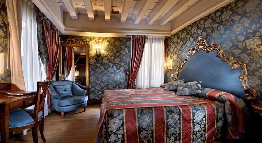 a hotel room with a bed and a chair, Suites Torre Dell Orologio in Venice