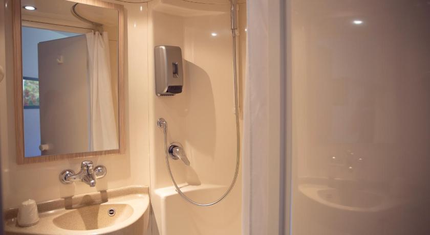 a bathroom with a shower, sink, and mirror, Premiere Classe Roissy - Aeroport Charles De Gaulle in Paris
