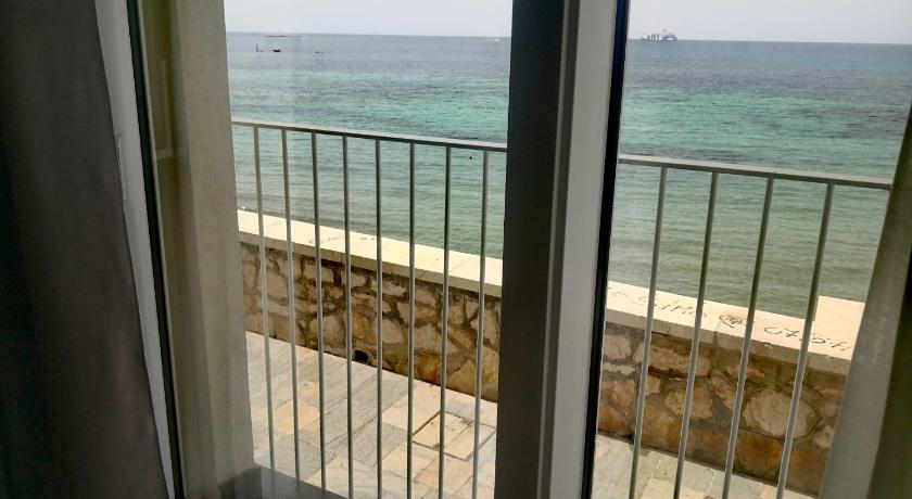 a view from a window of a balcony overlooking the ocean, Gaura Apartments in Trapani