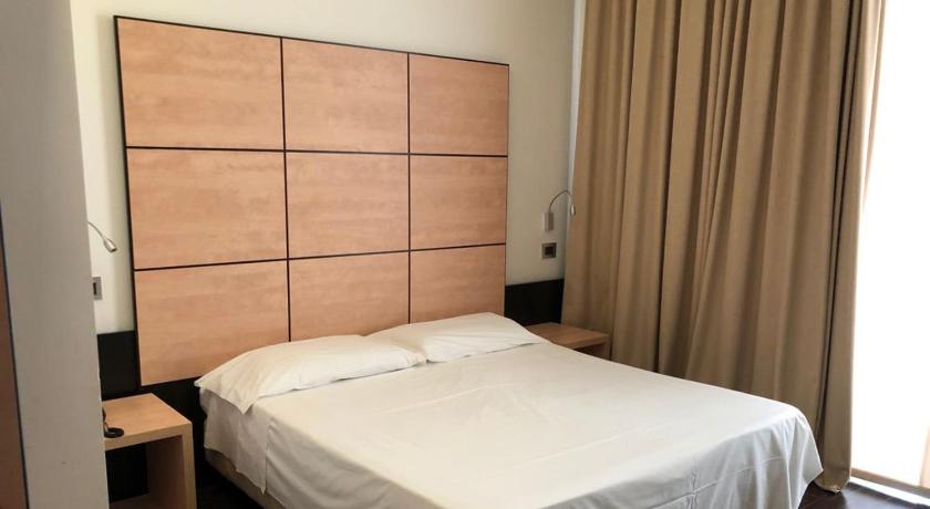 a hotel room with a bed and a dresser, Hotel Cimarosa in Naples