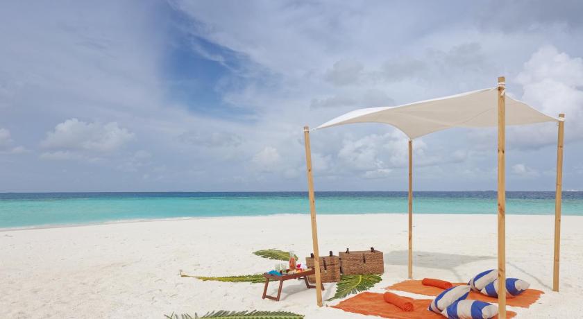 a sandy beach with umbrellas on the sand, Grand Park Kodhipparu Maldives in Maldive Islands