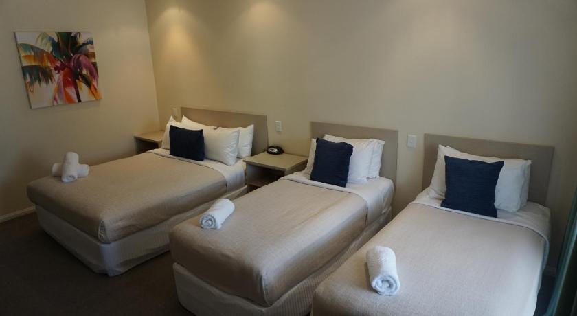 a hotel room with two beds and two couches, Lincoln Cottage Motor Inn in Wagga Wagga