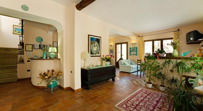 a living room filled with furniture and a large window, Hotel Moderno in Santa Teresa Gallura