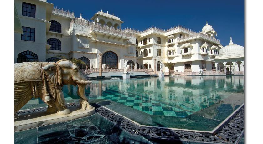 a large swimming pool with a statue of a man in it, The Shiv Vilas Resort in Jaipur