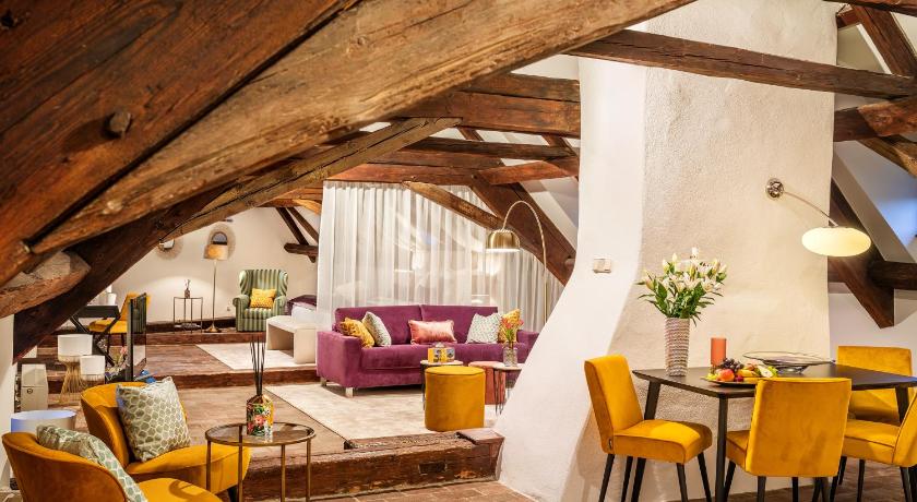 a living room filled with furniture and a large window, Hotel Bellevue in Cesky Krumlov