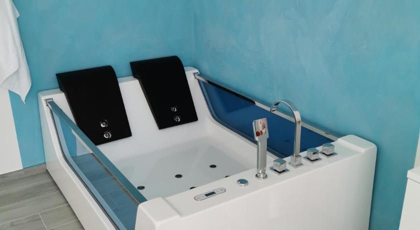 a white bath tub sitting next to a blue wall, IL CIELO SUL MARE in Bisceglie