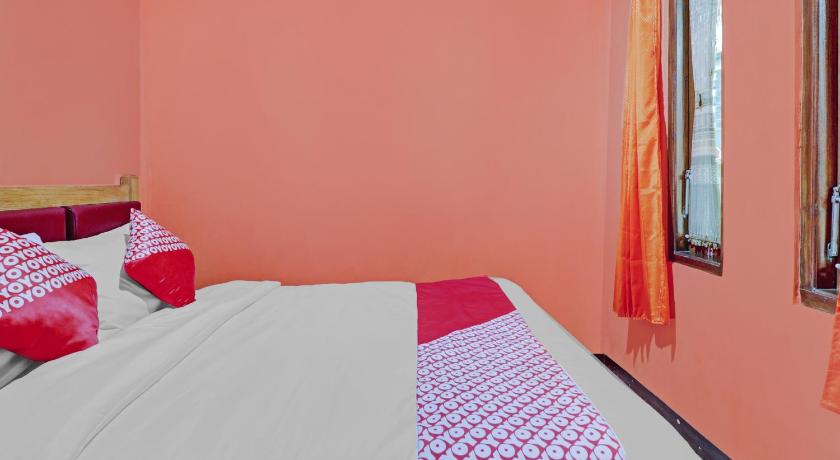 a bedroom with pink walls and blue curtains, OYO 90454 Adinda Homestay Cibodas Lembang in Bandung