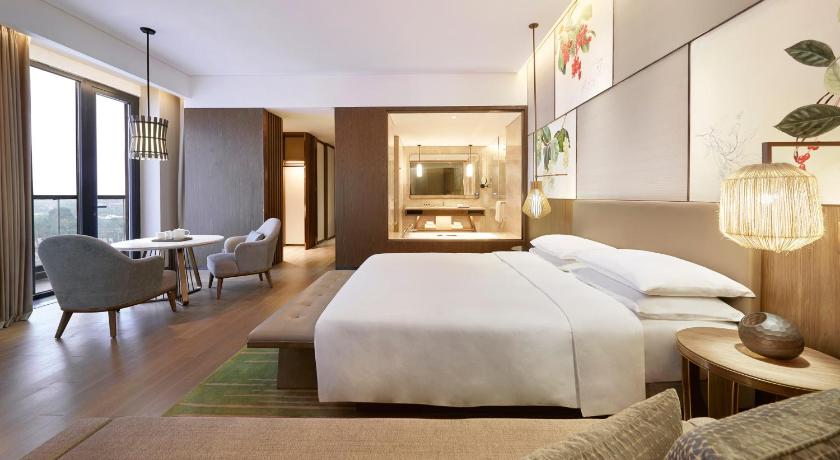 a hotel room with a bed, chair, table and television, Hyatt Regency Beijing Shiyuan in Beijing
