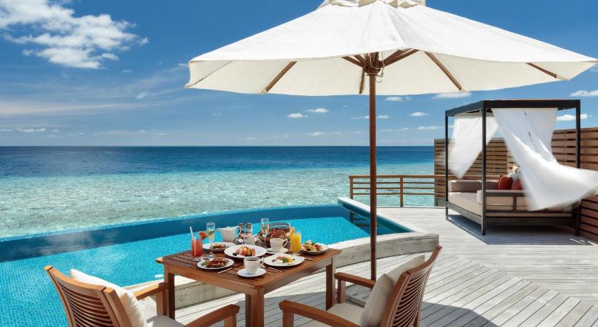 a dining room table with chairs and umbrellas, Baros Maldives in Maldive Islands