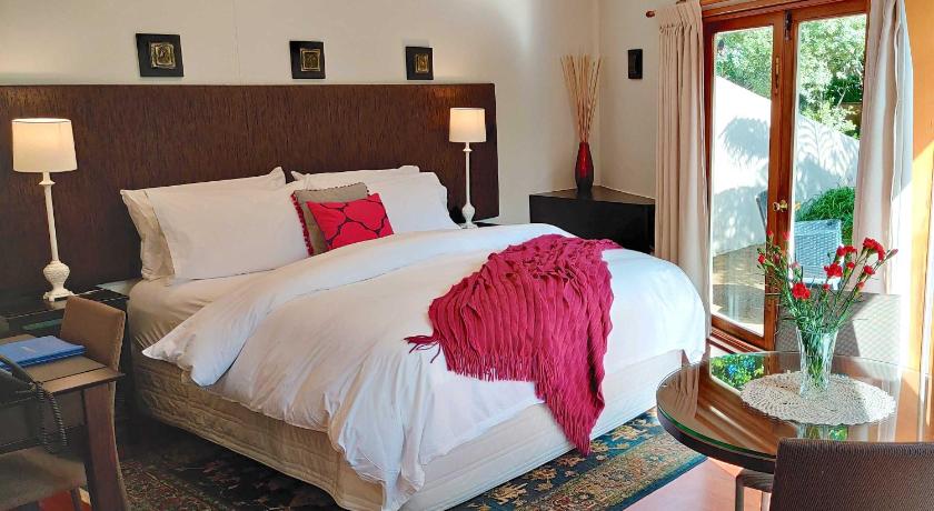 a hotel room with a bed and a dresser, Moon Gate Villa in Kerikeri