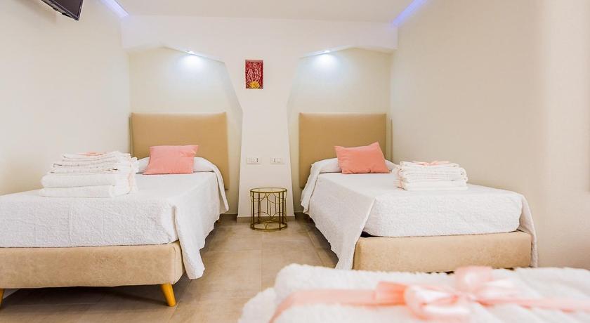 a hotel room with two beds and two lamps, HYPNOTIC GUESTHOUSE in Budoni