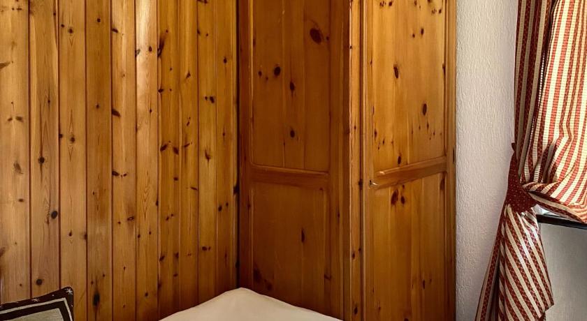 a bedroom with a bed and a dresser, Hotel Dei Camosci in Courmayeur