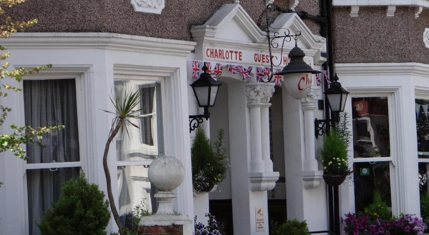 a street sign on a pole in front of a house, Charlotte Guest House in London