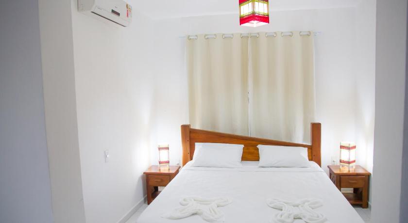 a bedroom with a bed and a lamp, Alto do Aeroporto Hotel in Porto Seguro
