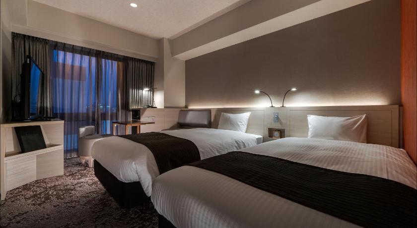 a hotel room with two beds and a large window, Daiwa Roynet Hotel Fukuoka-Nishinakasu in Fukuoka