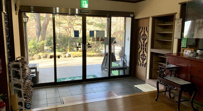 a living room filled with furniture and a window, Kusatsu Onsen Ryokufutei Ryokan in Kusatsu