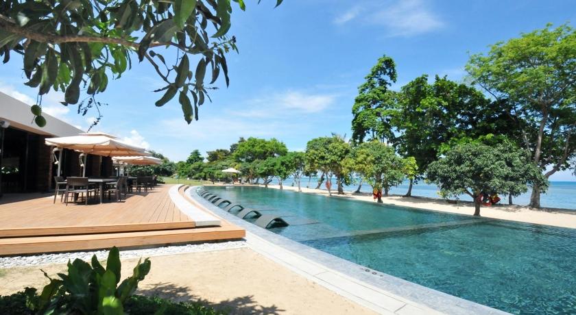 a beach area with a pool, chairs, and tables, Astoria Palawan Resort in Palawan