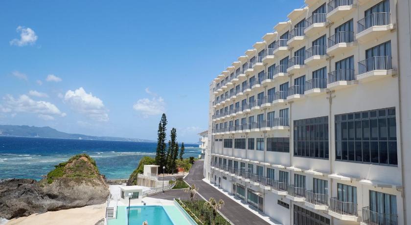 a large white building with a balcony overlooking the ocean, Hotel Miyuki Beach in Okinawa Main island