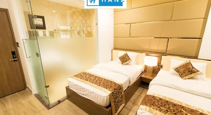 a hotel room with two beds and a television, HANZ Mymy Hotel in Ho Chi Minh City