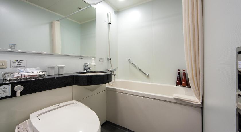a white toilet sitting next to a sink in a bathroom, Daiwa Roynet Hotel Okayama-Ekimae in Okayama