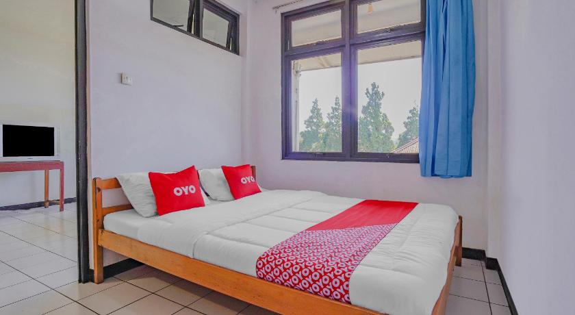 a bedroom with a bed and a window, OYO 90352 Villa Agape 2 in Puncak