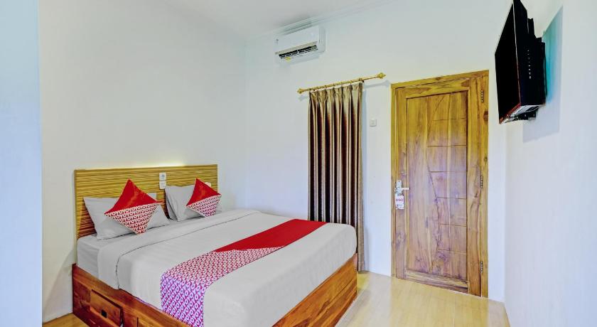 a bedroom with a bed and a dresser, OYO 90325 Pondok Dnayu Syariah in Yogyakarta