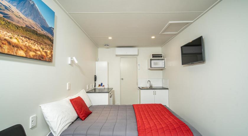 a bedroom with a bed, desk and a painting on the wall, Welcome Inn Motel Levin in Levin