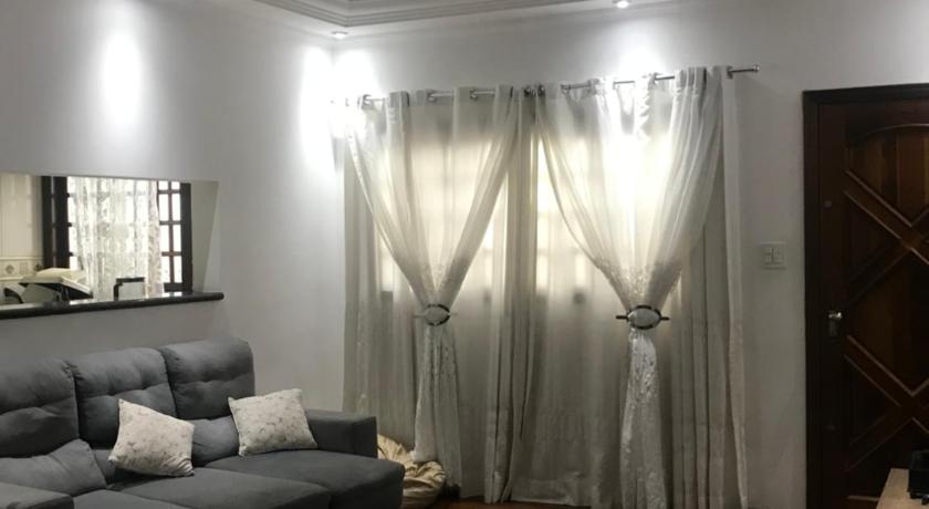 a living room filled with furniture and a large window, Hostel Comfort Airport Dutra e Shopping in Guarulhos