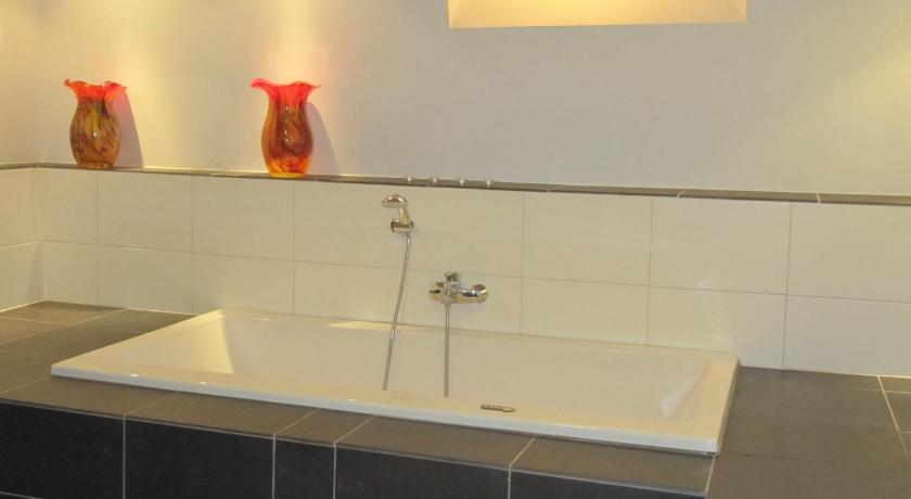 a bathroom with a sink, mirror, and bathtub, B&B Chez Cho in Utrecht